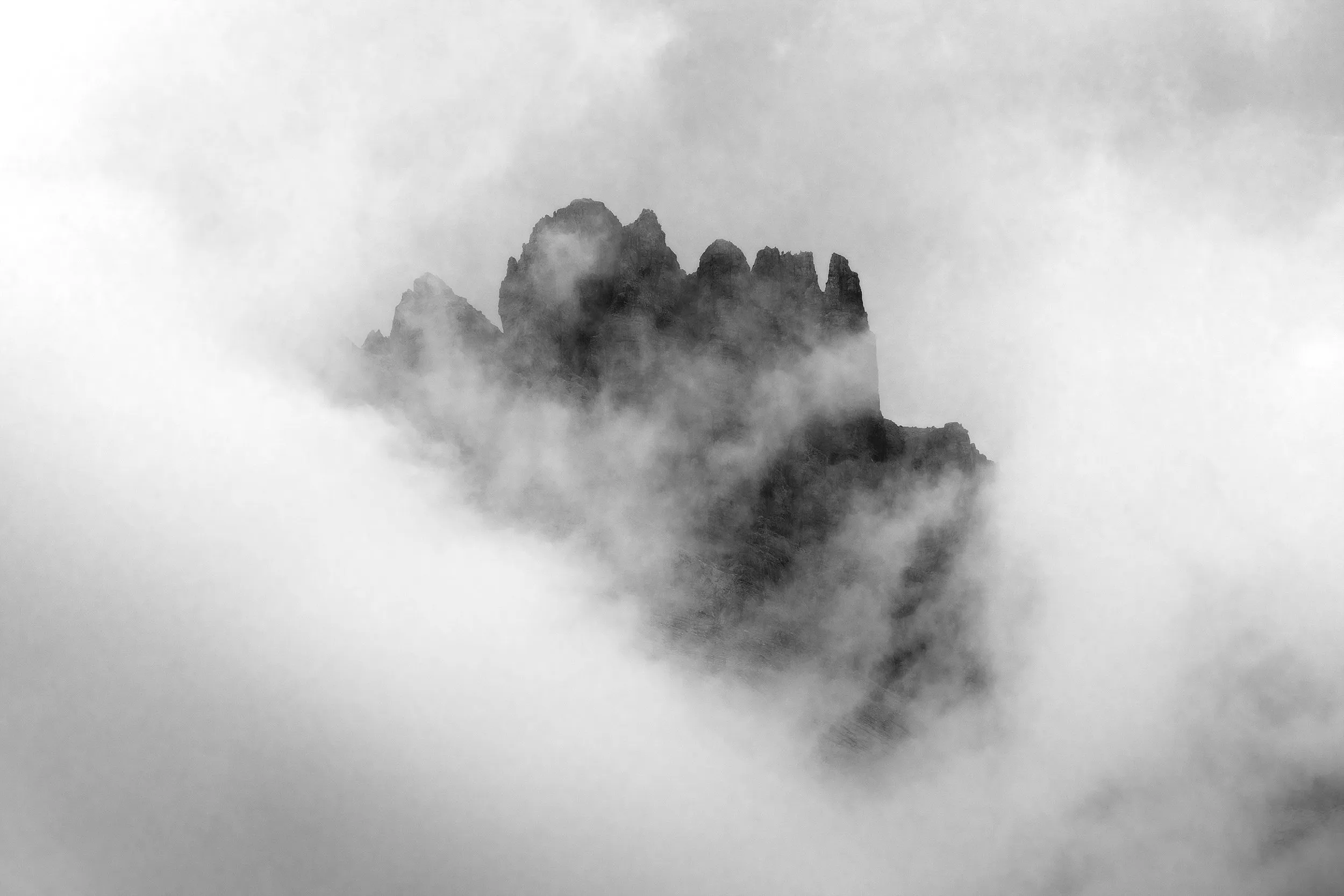 A peak half-lost in fog, in monochrome.