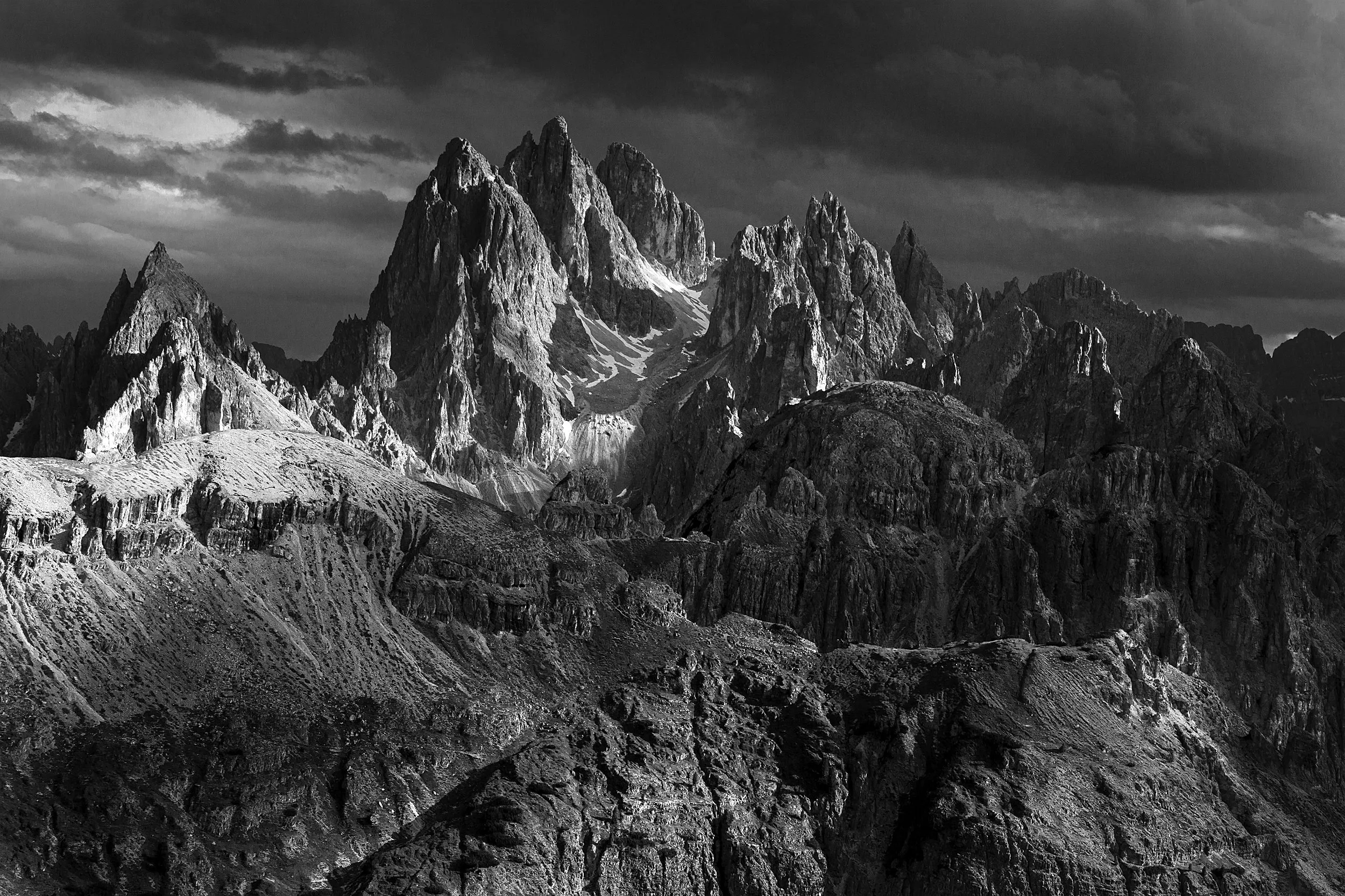 Rugged peaks under a dramatic sky, in monochrome.