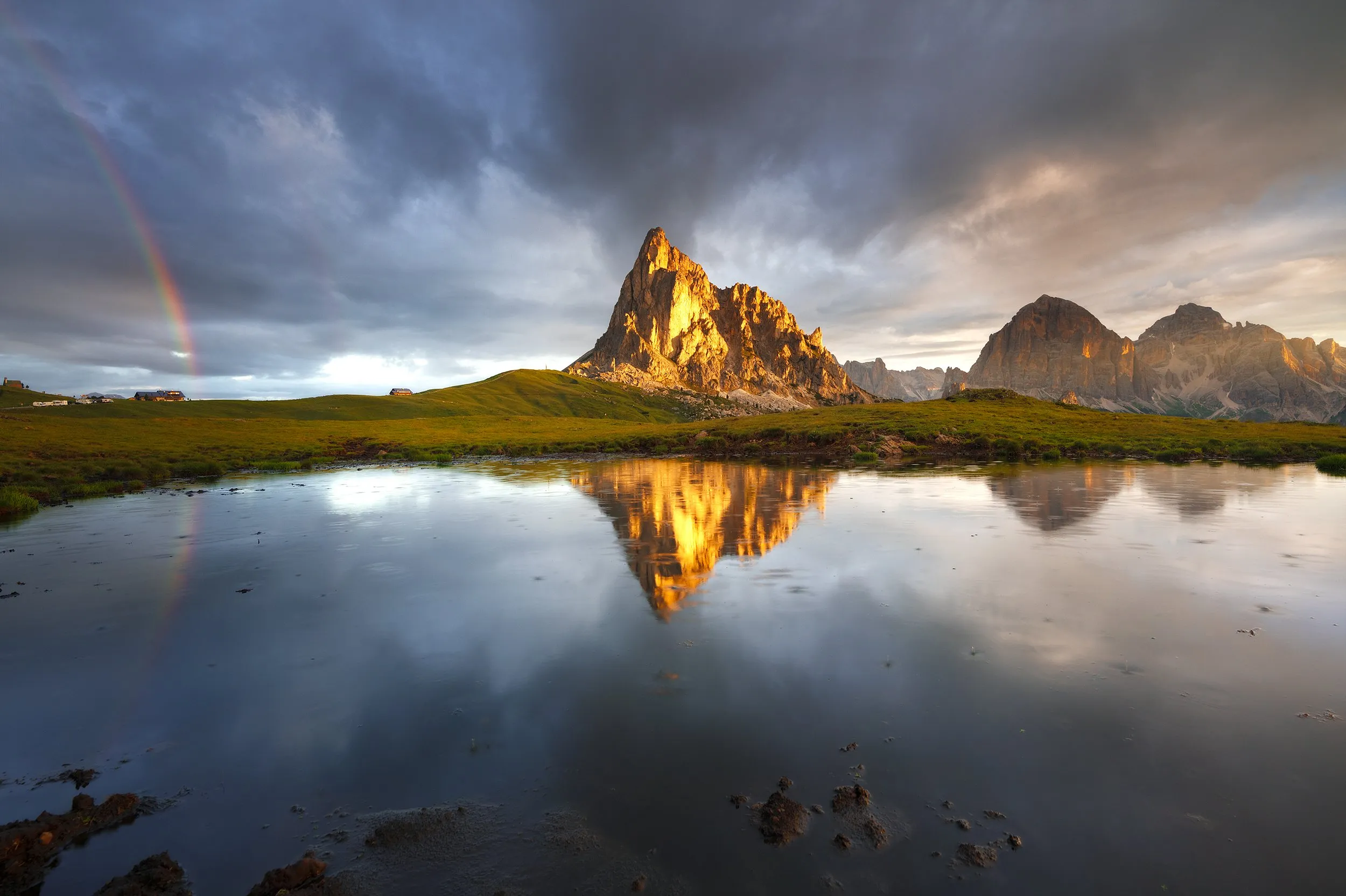 Rainbow over a mountain lake, framed by rugged peaks.