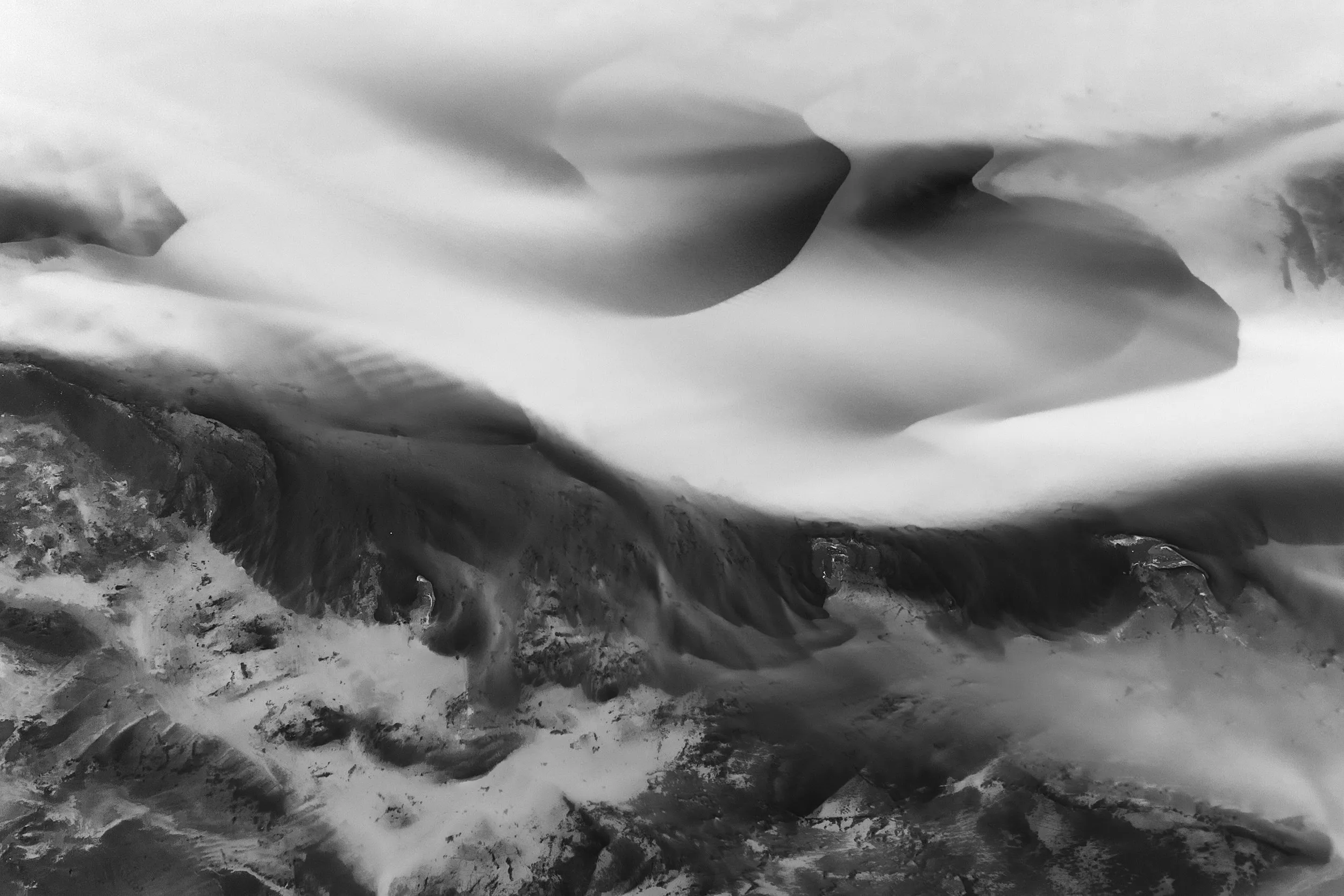 Glacier ice and jagged rock, in monochrome.