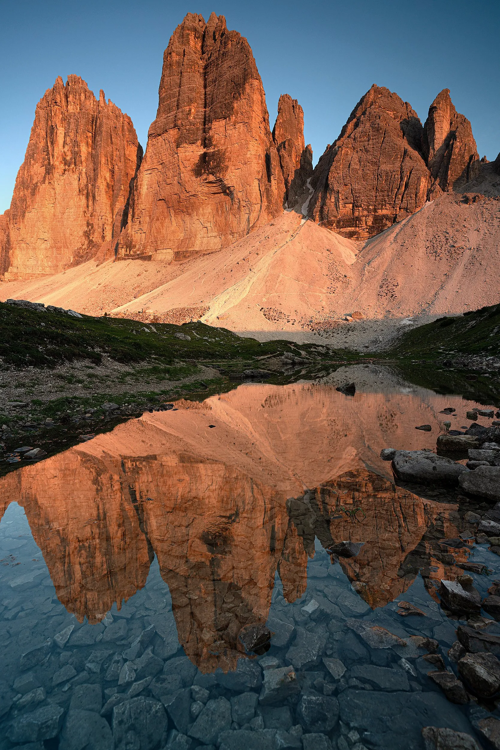 Sunlit peaks mirrored in a still mountain lake.